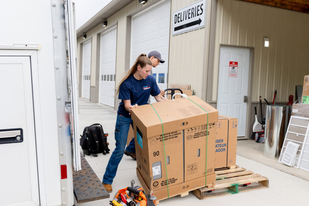 Employees of Warren Mechanical, LLC receiving a large HVAC equipment delivery at their warehouse in Carmel, IN.