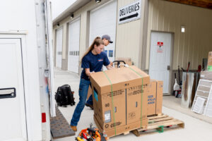 Employees of Warren Mechanical, LLC receiving a large HVAC equipment delivery at their warehouse in Carmel, IN.