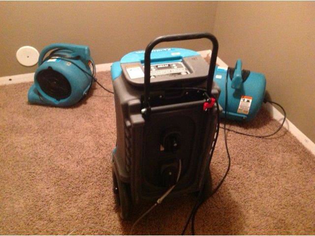 Water damage drying equipment, including dehumidifier and air movers, on carpet by Tex A Clean Carpet Care in League City, TX.