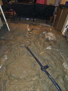 Water damage restoration work on a muddy floor, a service provided by Big Red Flooring in Omaha, NE