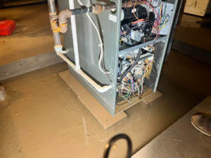 A water-damaged furnace or air handler unit requiring service from Preston Heating and Air Conditioning in Rochester, NY.