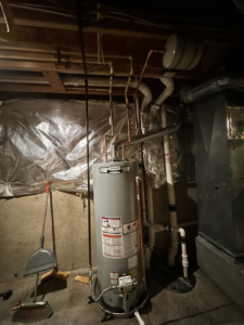 A comprehensive view of a water heater and HVAC system components in a utility room by Adonis Hvac in Annapolis, MD.