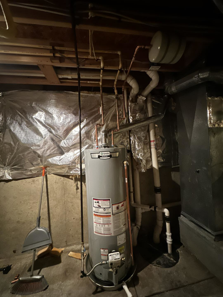 A comprehensive view of a water heater and HVAC system components in a utility room by Adonis Hvac in Annapolis, MD.