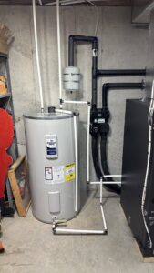 A water heater with intricate piping and an adjacent HVAC unit, demonstrating Prime Home HVAC's installation expertise in York, PA.