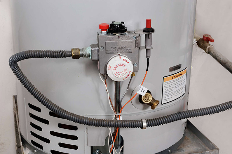 Close-up of a water heater's control panel and gas lines, serviced by Climate Care Heating & Air Conditioning in Norwalk, CT