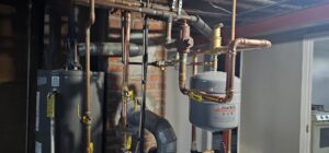 A water heater and expansion tank with new copper piping installed by Allied Heating and Air Conditioning in Port Richey, FL.