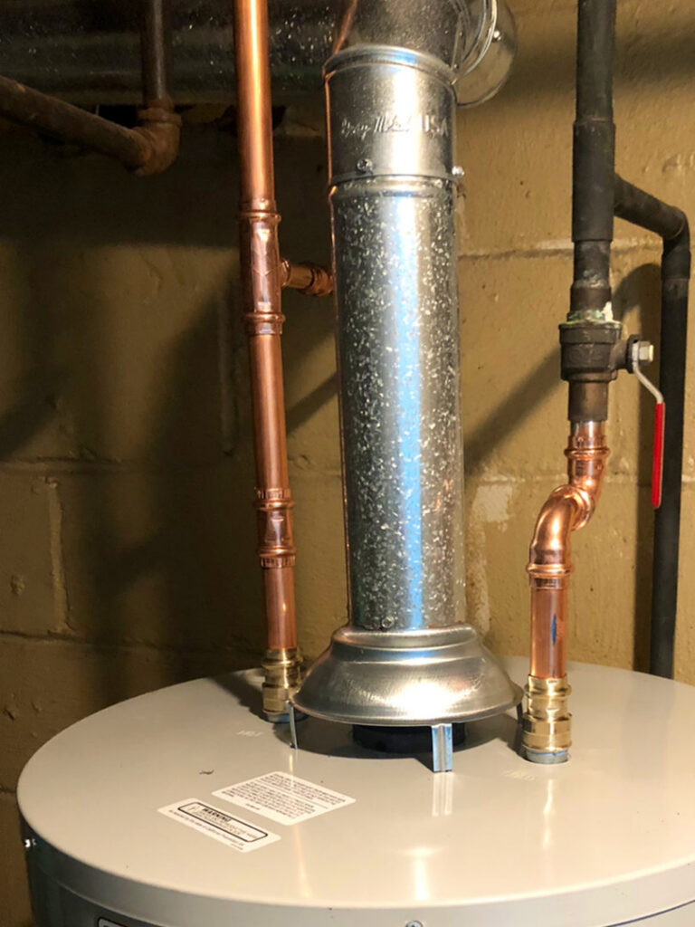A water heater with new copper piping and a galvanized exhaust flue installed by Ohio City Heating and Cooling in Cleveland, OH.