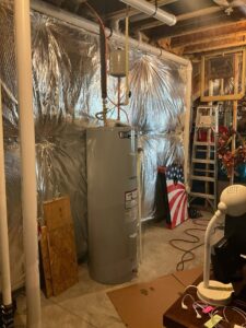 A water heater installed in a utility area with reflective insulation, serviced by Markool Heating Cooling Plumbing in Frederick, MD.