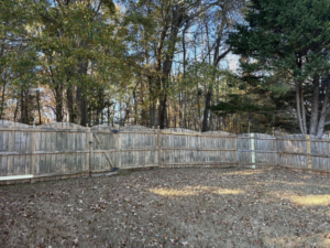 An older wooden fence with a gate, showing signs of wear and potential repair work by Myers & Dunlap Fence Repair in Greenville, SC.