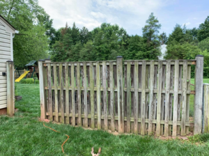 A weathered wooden privacy fence showing signs of age, ready for replacement by Arias Fence & Repair in Manassas, VA.