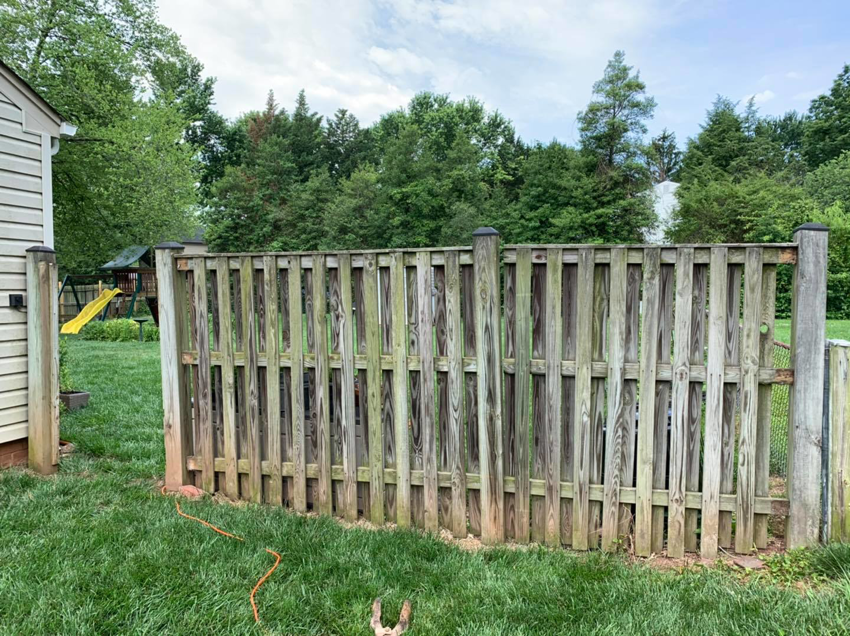 A weathered wooden privacy fence showing signs of age, ready for replacement by Arias Fence & Repair in Manassas, VA.