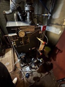 A Weil-McLain boiler with a Carlin oil burner installed in a utility room by L&SON Heat AC Tech in Yonkers, NY.