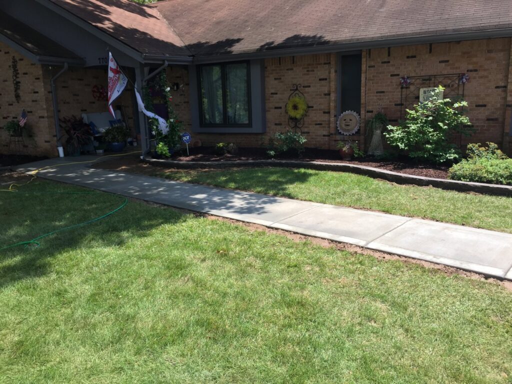 A beautifully well-maintained front yard with lush grass and mulched landscaping by Creamer Construction LLC in Saint Peters, MO.