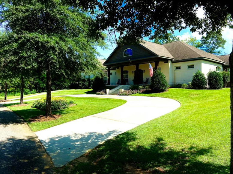A well-maintained front yard with a lush green lawn and clean driveway by NewLeaf Lawn Care LLC in Dothan, AL.