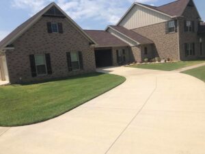 A beautifully well-maintained green lawn and clean driveway by L&L Lawn Care Service in Dothan, AL.
