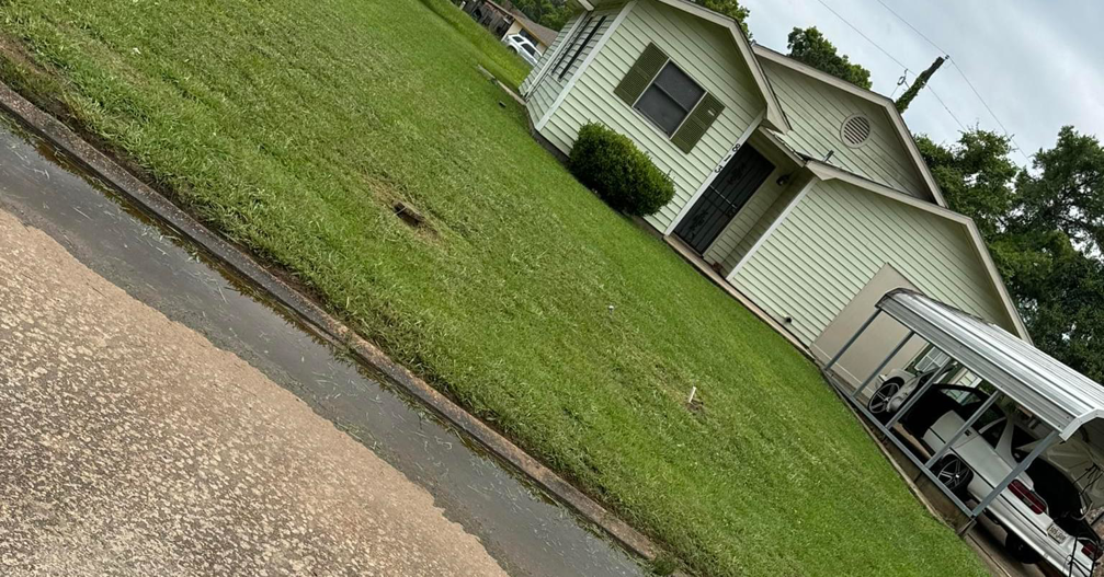A well-maintained green lawn in front of a house by Minors lawn care service in Canton, OH.