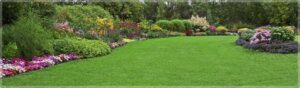 A beautifully well-maintained lawn with a vibrant landscaped border by Kustom Lawn Kare LLC in Greenwood, IN.