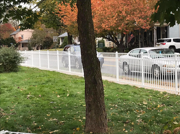 A newly installed white aluminum fence lining a residential property by Mercer Fence Company in Hamilton Township, NJ.