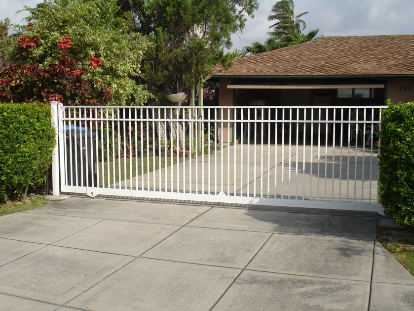 A white automatic sliding gate installed at a residential driveway by Allied Security Fence in Kapolei, HI