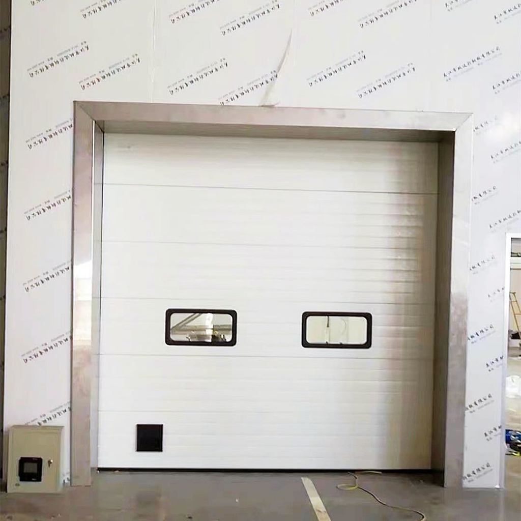 A white commercial sectional garage door with two windows installed by Hines Garage Doors Service & Repair in Seattle, WA.