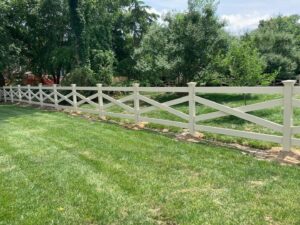 A white cross-buck style fence installed in a residential yard by Sea Level Fence in Harbinger, NC