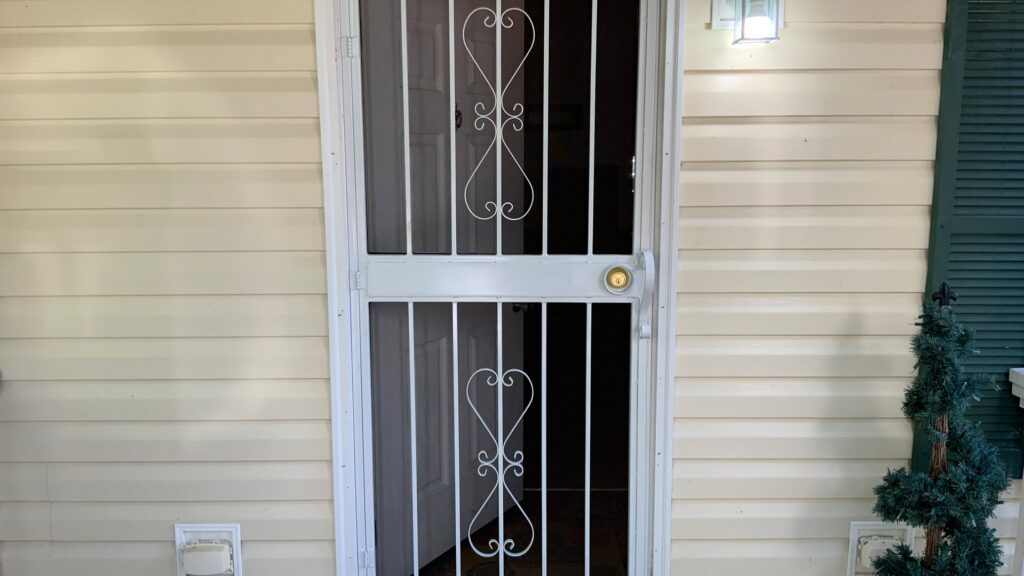 White decorative security screen door with heart-shaped elements by Ability Burglar Bars in Jacksonville, FL.