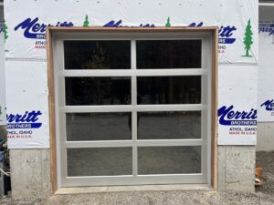 A modern white full-view glass garage door installed on a new construction by Remarkable Door Company in Spokane, WA.