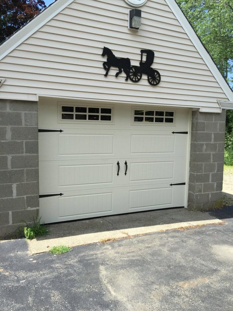 A white garage door with decorative hardware and top windows installed by Snowbird Garage Doors Company in Worcester, MA.