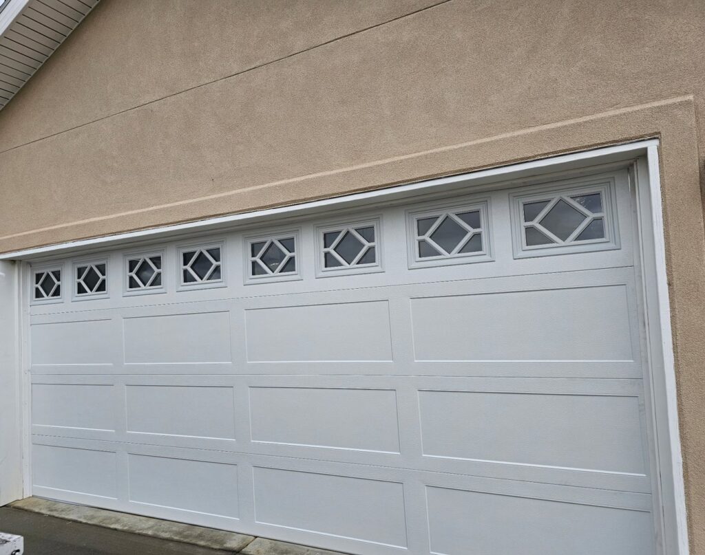 A white garage door with unique decorative window inserts, installed by Prutch's Garage Door in Colorado Springs, CO.