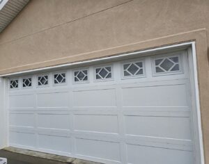 A white garage door with unique decorative window inserts, installed by Prutch's Garage Door in Colorado Springs, CO.