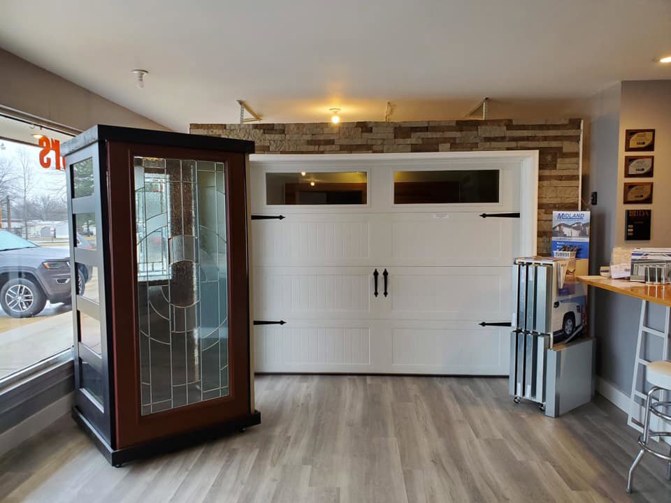 A white carriage house style garage door on display in the showroom of 314 Overhead Doors in O'Fallon, MO.