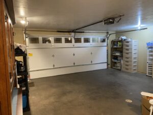 A newly installed white garage door with windows and opener inside a garage by AJK Door Services in Duluth, MN.