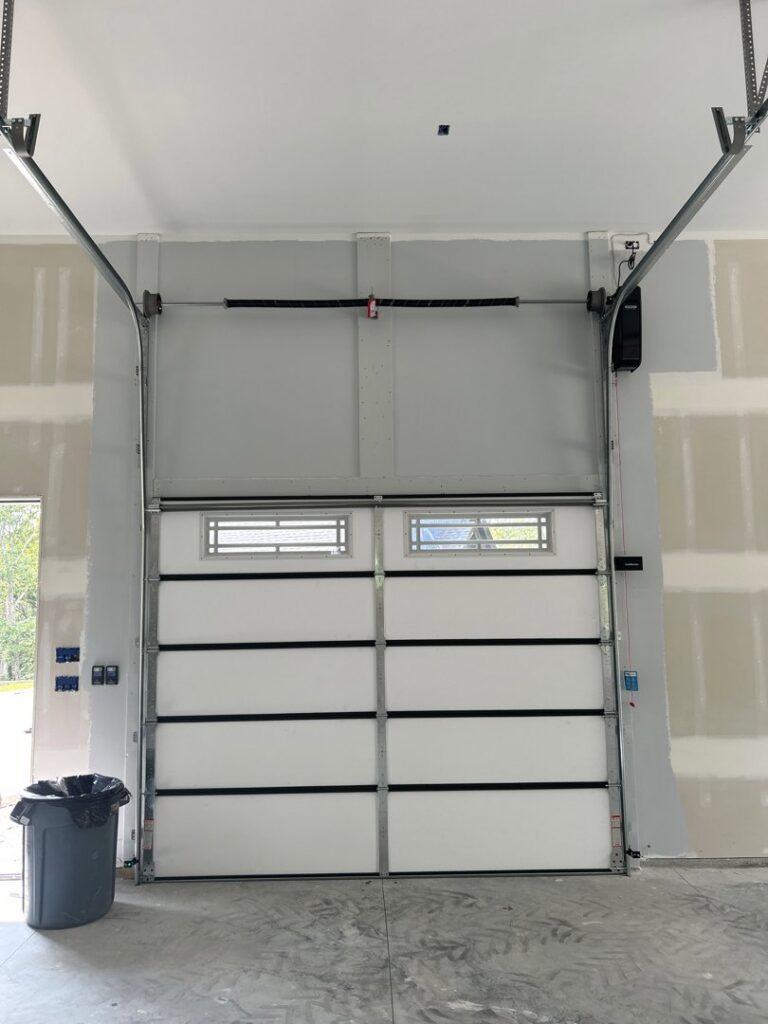 A white garage door with windows and an automatic opener installed by 314 Overhead Doors in O'Fallon, MO.