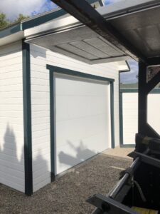 A newly installed white garage door on an outbuilding by Colorado Garage Door Guy in Aurora, CO.