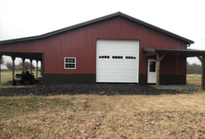 A white panel garage door installed on a red barn-style building by Smith's Garage Door in Clarksville, TN.