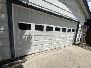 A newly installed white garage door with square window panels on a residential home by Prutch's Garage Door in Page, AZ