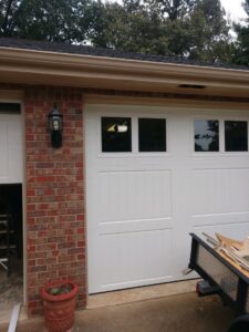 A white garage door with windows, partially open, showcasing the interior of a garage, installed by Ken's Overhead Door, Clarksville, TN.