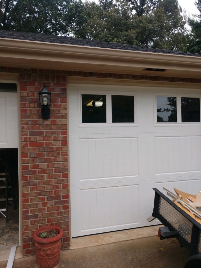 A white garage door with windows, partially open, showcasing the interior of a garage, installed by Ken's Overhead Door, Clarksville, TN.