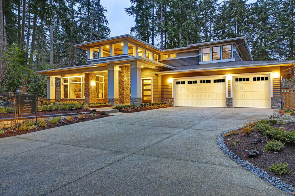 Two white garage doors with top windows installed on a modern house by Access Garage Doors-Chattanooga, TN
