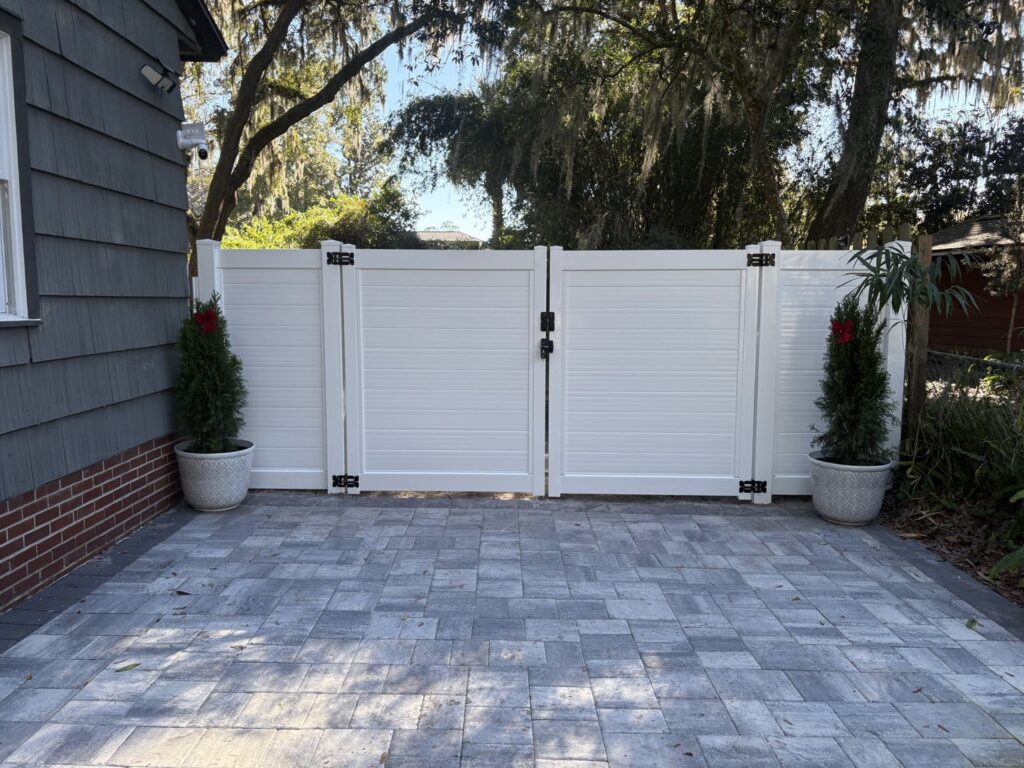A modern white horizontal slat fence with double gates, installed by Masters Fence Contracting in Jacksonville, FL.