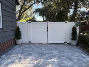 A modern white horizontal slat fence with double gates, installed by Masters Fence Contracting in Jacksonville, FL.