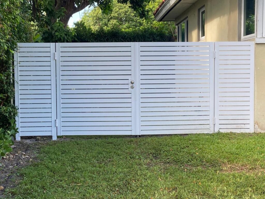 A modern white horizontal slat fence with a gate installed by Palm's Fence of Miami, FL.