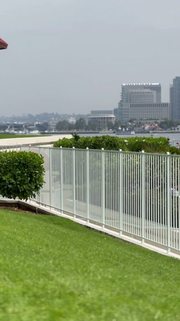 A white metal picket fence overlooking a city view, installed by San Diego Fencing Contractor A's Pro Build Fencing in San Diego, CA.