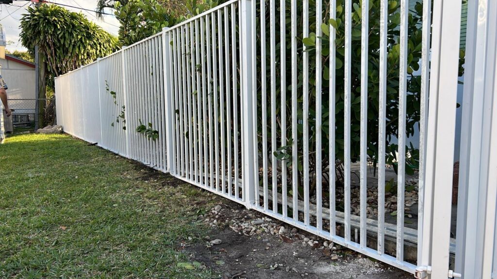 A white metal picket fence installation by Palm's Fence of Miami, FL.