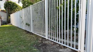 A white metal picket fence installation by Palm's Fence of Miami, FL.