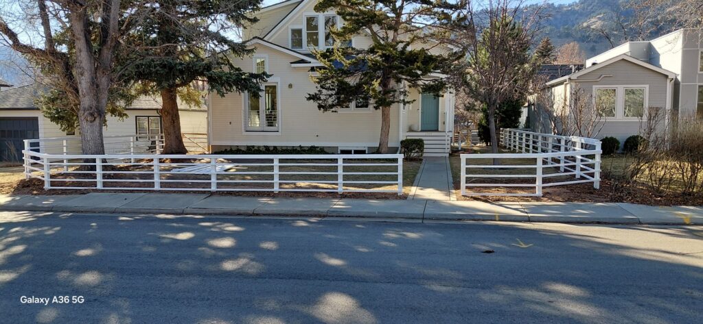 A white metal pipe fence installed in front of a residential property by Done Wright Fencing and Welding in Denver, CO.