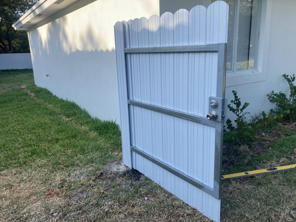 A newly installed white metal privacy gate next to a residential building by Allende J. Service Corp in Miami, FL.