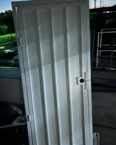 A newly installed white metal security gate by Rossi Welding Metal, a fencing contractor in Los Angeles, CA.