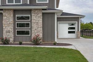 A stylish white modern garage door with vertical windows installed on a residential home by Overhead Door Company of Maricopa & Pinal County in Mesa, AZ.
