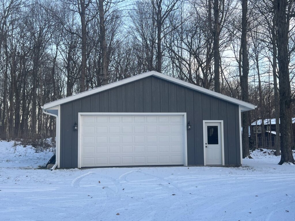 A newly installed white panel garage door on a modern grey building by McDonald Overhead Door Inc. in Kenosha, WI.
